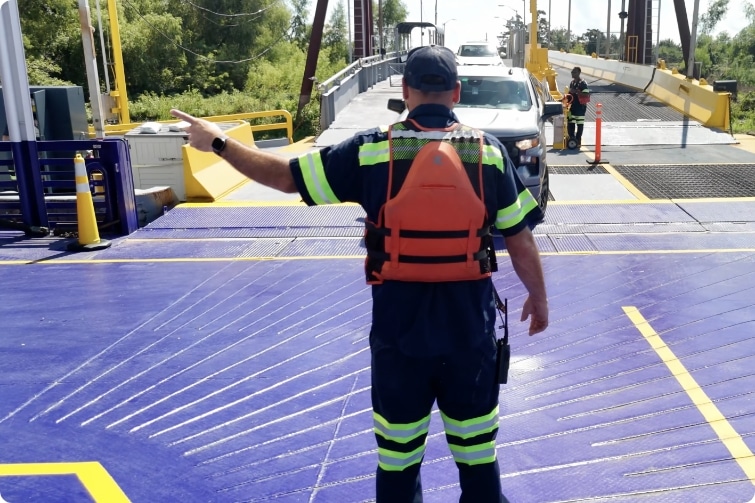 ferry employee guiding drivers